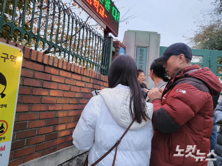 16일 오전 서울 중구 이화여자고등학교 정문 앞에서 수험생을 위해 기도하는 가족들. 박희영 기자
