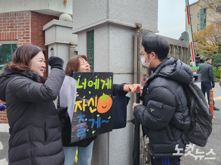 2024학년도 대학수학능력시험이 치러지는 11일 부산의 한 고등학교 앞에서 수험생이 교사들의 응원을 받으며 고사장으로 들어가고 있다. 정혜린 기자