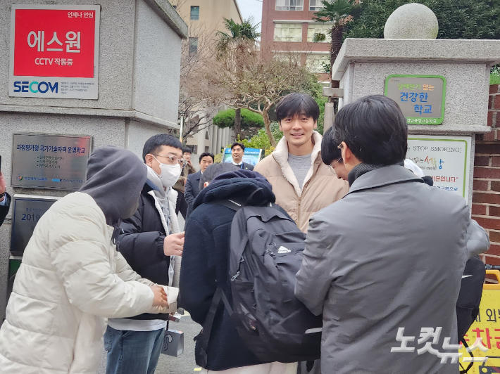 2024학년도 대학수학능력시험이 치러지는 11일, 부산의 한 고등학교 앞에서 수험생이 부모와 교사들의 응원을 받으며 고사장으로 들어가고 있다. 정혜린 기자