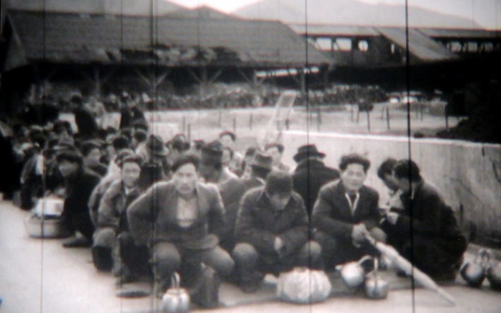 미국 국립문서관리청 영상자료 캡처. 1949년 3월 일본 나가사키에서 출발해 부산항에 도착한 '다치바나 마루' 여객선 승객들이 나란히 앉아 있다. 강제 송환되는 도민들도 포함돼 있다. 전갑생 연구원 제공