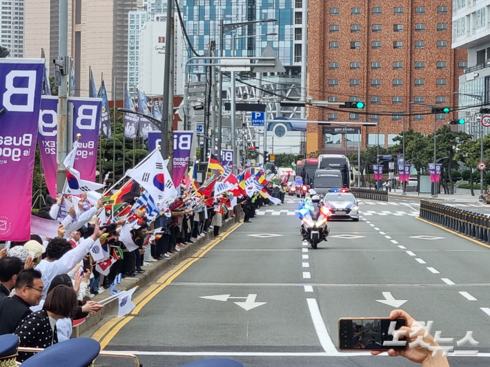 지난 4월 부산 해운대해변로에서 시민들이 국제박람회기구(BIE) 실사단이 탄 버스를 향해 손을 흔들고 있다. 박진홍 기자