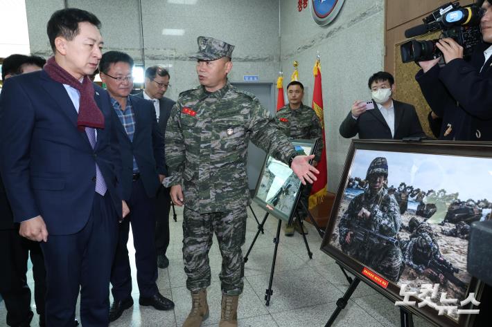 김기현 국민의힘 대표가 21일 경기도 김포 해병대 제2사단 청룡회관에서 정종범 해병대 제2사단장의 안내로 청룡부대 훈련 사진을 살펴보고 있다.
