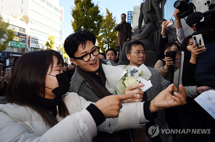 (대전=연합뉴스) 김준범 기자 = 한동훈 법무부 장관이 21일 오전 대전광역시 한국어능력 등 사회통합프로그램 CBT 평가 대전센터 개소식에 참석, 차에서 내리며 지지자와 셀카를 찍고 있다. 2023.11.21 [공동취재] psykims@yna.co.kr 연합뉴스