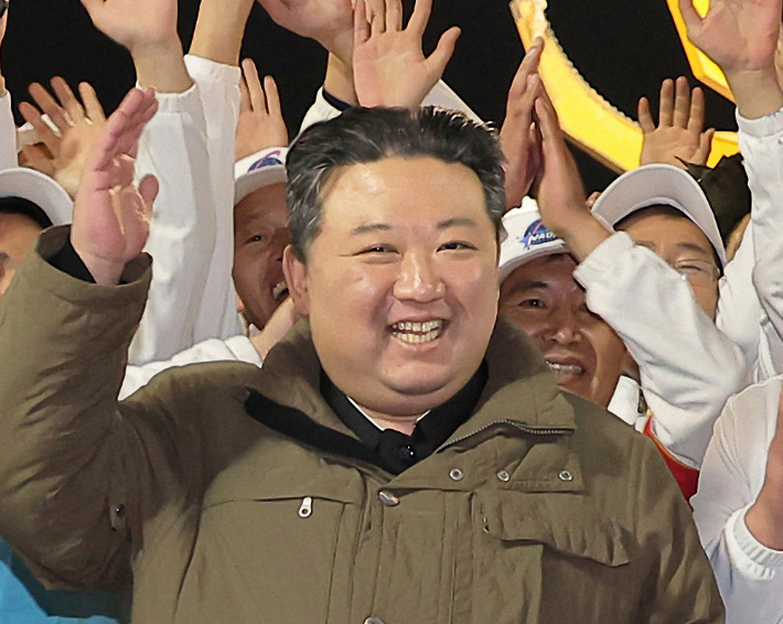 북한은 22일 전날 밤 발사한 군사정찰위성 1호기 '만리경-1호'의 발사가 성공적으로 이뤄졌다고 밝혔다. 관계자들과 함께 손을 흔드는 김정은. 연합뉴스