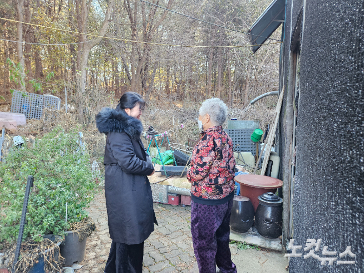 24일 오전 경기도 고양시 덕양구 흥도동의 한 비닐하우스 앞에서 A(85) 할머니가 명장텐에서 기부한 빵을 전달한 생활지원사 유수현(48,여)씨를 배웅하고 있다. 고무성 기자