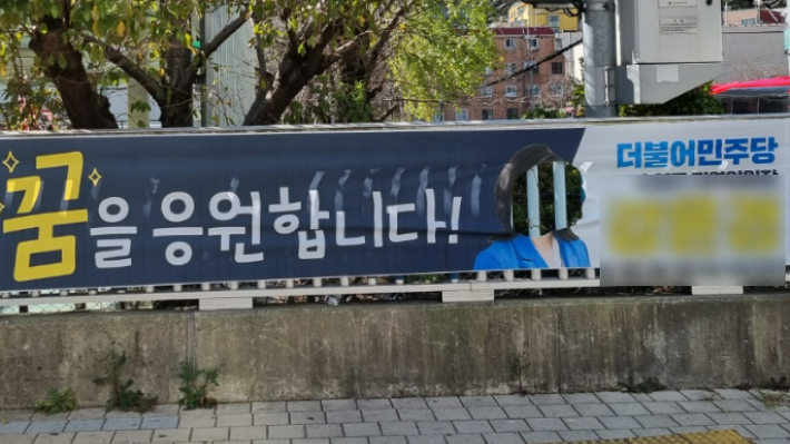 부산 수영구 망미동의 한 아파트 앞에 설치된 한 정당 지역위원장 현수막이 얼굴 부분만 훼손된 채 발견됐다. 부산 수영구의회 권진성 의원 제공  