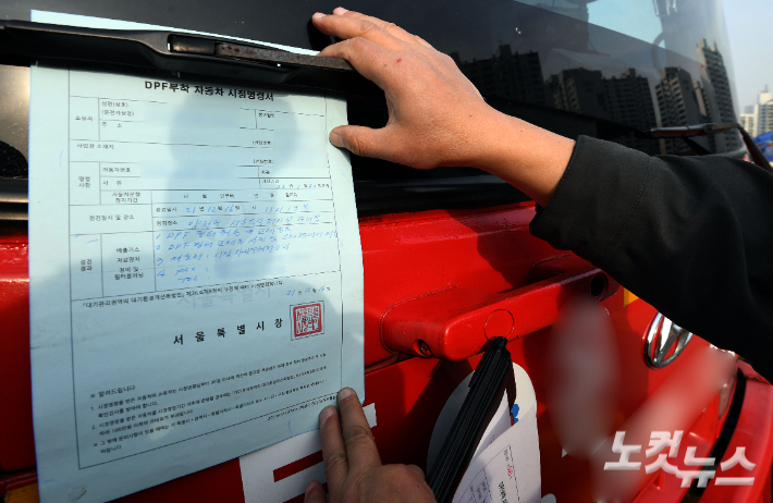 서울 양천구 서부트럭터미널에서 서울시청 차량공해저감과 직원들이 노후 경유차량 매연저감장치 작동여부를 점검 후 시정명령서를 부착하고 있다. 황진환 기자