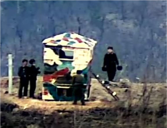 북한군이 목재로 구조물을 만들고 얼룩무늬로 도색하는 모습. 국방부 제공