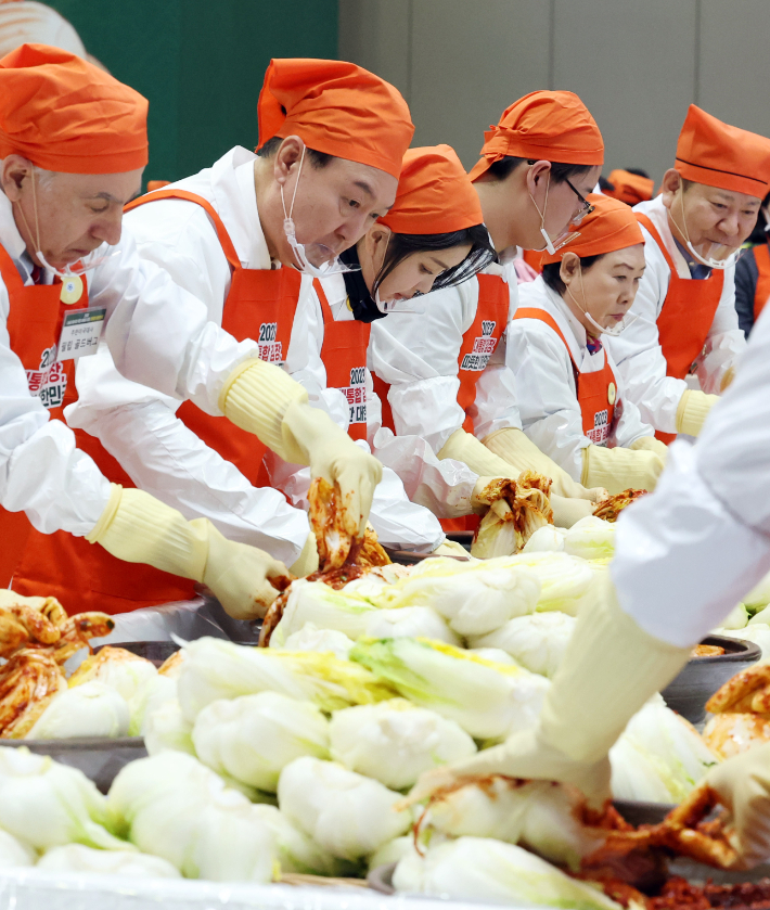 윤석열 대통령과 부인 김건희 여사가 27일 경기 고양 일산 킨텍스에서 열린 '나눔과 봉사의 국민 대통합 김장행사'에서 김치를 담그고 있다. 연합뉴스