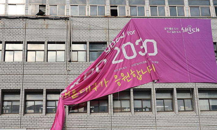 부산 해운대구청사 외벽에 걸려 있던 엑스포 응원 현수막이 철거되고 있다. 연합뉴스