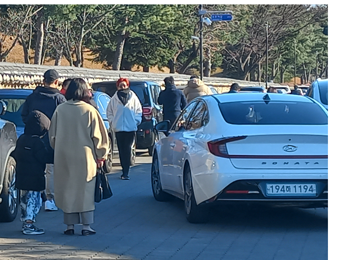경주 대릉원 돌담길 모습. 세워진 차량 사이로 관광객들이 지나고 있다. 경주시 제공