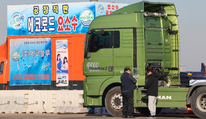 중국 당국이 한국으로의 산업용 요소 통관을 보류한 가운데 4일 인천 연수구 인천신항 인근 도로변에서 대형화물차 운전기사가 요소수를 넣고 있다. 연합뉴스