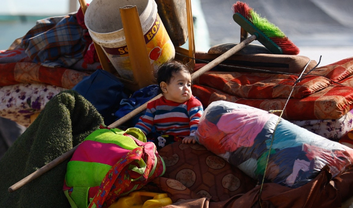 이스라엘과 팔레스타인 무장 정파 하마스 간 충돌이 격화되는 가운데 지난 6일(현지시간) 가자지구 남부 라파의 한 난민 캠프로 피신한 아이가 물건 더미에 앉아 있다. 연합뉴스