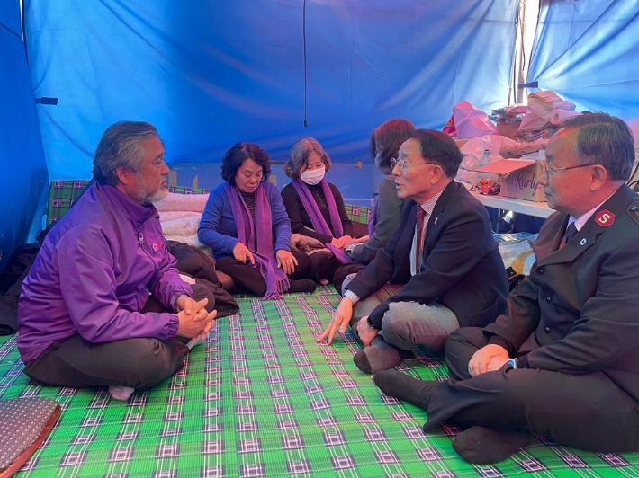 한국기독교교회협의회 기독교사회봉사위원회가 12일 오후 서울 여의도 국회의사당 앞 이태원참사특별법 제정 위한 농성장을 찾았다.  교회협의회 김종생 총무를 비롯한 관계자들은 유가족들의 어려움을 나누며 사회적기업이 생산한 생필품 40박스를 성탄 선물로 전달했다. (사진 = 한국기독교교회협의회 기독교사회봉사위원회)