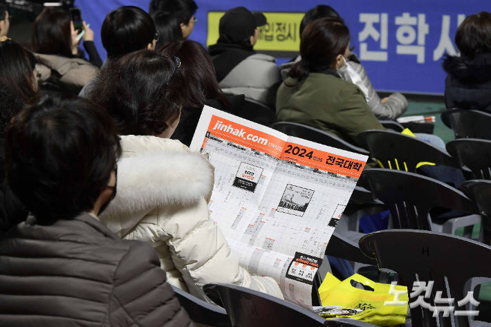 14일 서울 잠실학생체육관에서 열린 진학사 2024 정시 합격전략 설명회에 참석한 수험생 및 학부모들이 자료를 살펴보고 있다. 박종민 기자