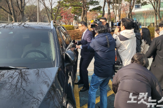 지난달 23일 열린 1차 공판 이후 취재진에 둘러 쌓여 차량에 탑승하고 있는 윤석열 대통령의 처남 김씨. 이준석 기자