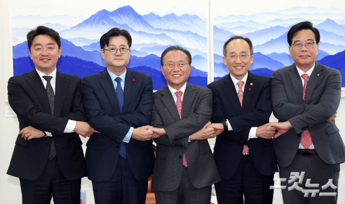 국민의힘 윤재옥 당대표 권한대행 겸 원내대표와 더불어민주당 홍익표 원내대표가 20일 서울 여의도 국회 운영위원장실에서 2024년도 예산안 처리를 위한 합의문을 발표하며 손을 맞잡고 있다.(왼쪽부터 더불어민주당 강훈식 예결위 간사, 홍익표 원내대표, 국민의힘 윤재옥 권한대행, 추경호 경제부총리 겸 기획재정부 장관, 송언석 예결위 간사) 윤창원 기자
