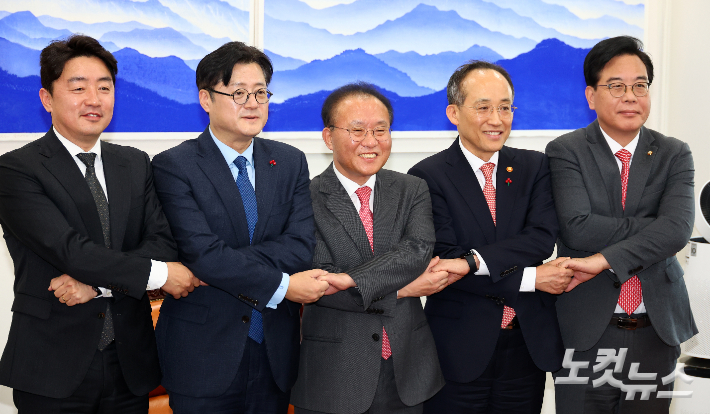 국민의힘 윤재옥 당대표 권한대행 겸 원내대표와 더불어민주당 홍익표 원내대표가 20일 서울 여의도 국회 운영위원장실에서 2024년도 예산안 처리를 위한 합의문을 발표하며 손을 맞잡고 있다.(왼쪽부터 더불어민주당 강훈식 예결위 간사, 홍익표 원내대표, 국민의힘 윤재옥 권한대행, 추경호 경제부총리 겸 기획재정부 장관, 송언석 예결위 간사) 윤창원 기자