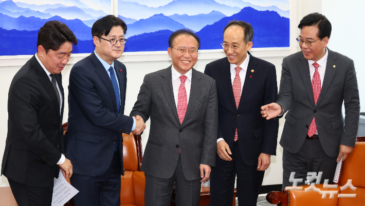 국민의힘 윤재옥 당대표 권한대행 겸 원내대표와 더불어민주당 홍익표 원내대표가 20일 서울 여의도 국회 운영위원장실에서 2024년도 예산안 처리를 위한 합의문을 발표하며 악수를 하고 있다.(왼쪽부터 더불어민주당 강훈식 예결위 간사, 홍익표 원내대표, 국민의힘 윤재옥 권한대행, 추경호 경제부총리 겸 기획재정부 장관, 송언석 예결위 간사) 윤창원 기자