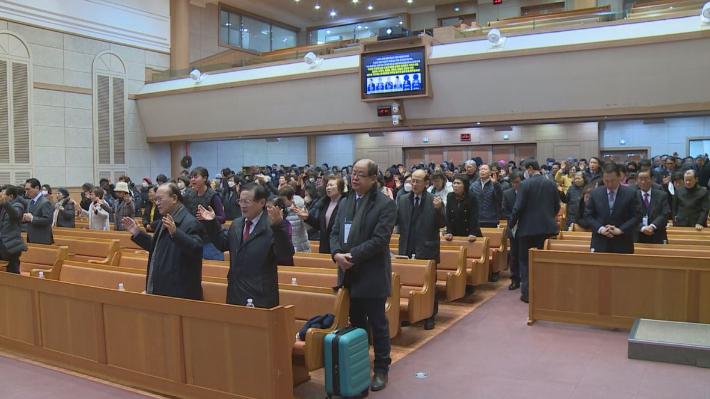 목회자들과 성도들이 모두 일어나 기도하고 있다.