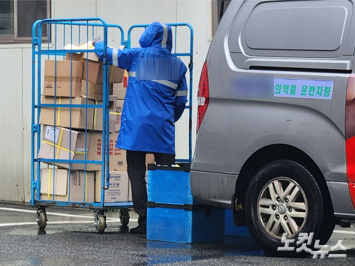 한 의약품 유통업체가 부산 사상구 한 야외주차장에서 비가 오는 날씨에도 상하차 작업을 벌이고 있는 모습. 정혜린 기자