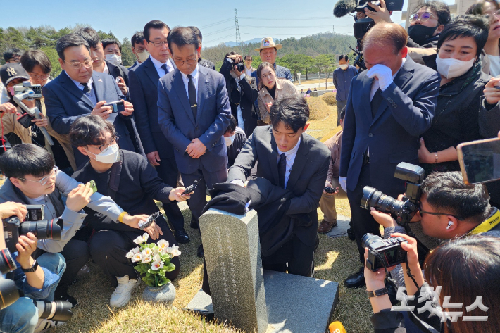 고 전두환씨 손자 전우원씨가 지난 3월 31일 국립 5·18 민주묘지를 참배하며 자신이 겉옷으로 묘비를 닦고 있다. 박요진 기자