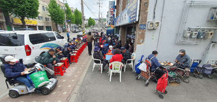 인천 서구 석남동 무료급식소인 '나눔의 울타리' 앞에서 주민들이 점심식사를 하는 모습. 광명의집 제공