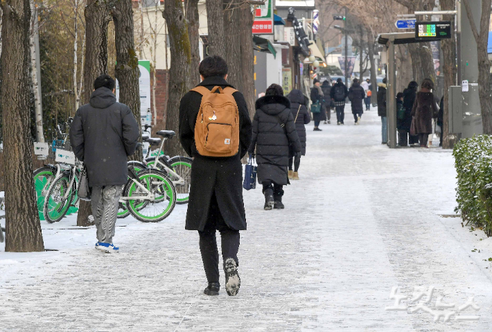 20일 서울 경복궁역 인근에서 시민들이 전날 내린 눈으로 미끄러워진 인도를 걷고 있다. 박종민 기자