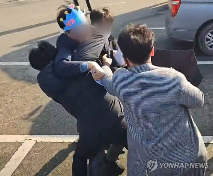 (부산=연합뉴스) 2일 부산 가덕도 신공항 부지를 방문한 더불어민주당 이재명 대표를 흉기로 공격한 피의자가 현장에서 경찰에 체포되고 있다. 2024.1.2 [바른소리 TV 유튜브 캡처. 재판매 및 DB금지] photo@yna.co.kr 연합뉴스