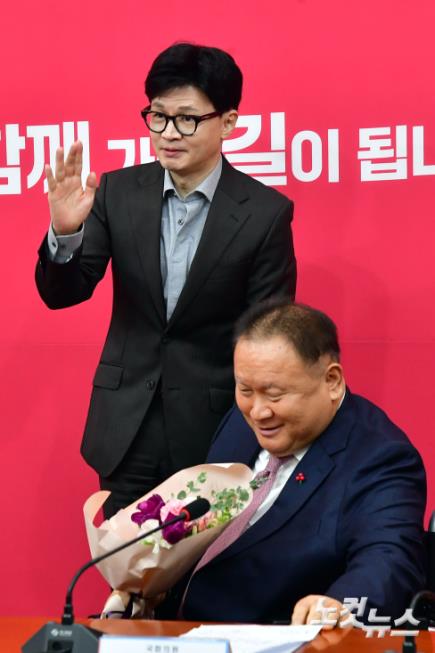 국민의힘 한동훈 비상대책위원장이 8일 서울 여의도 국회에서 열린 비상대책위원회의에서 국민의힘에 입당한 이상민 의원에게 꽃다발을 전달하고 기념촬영을 하고 있다.
