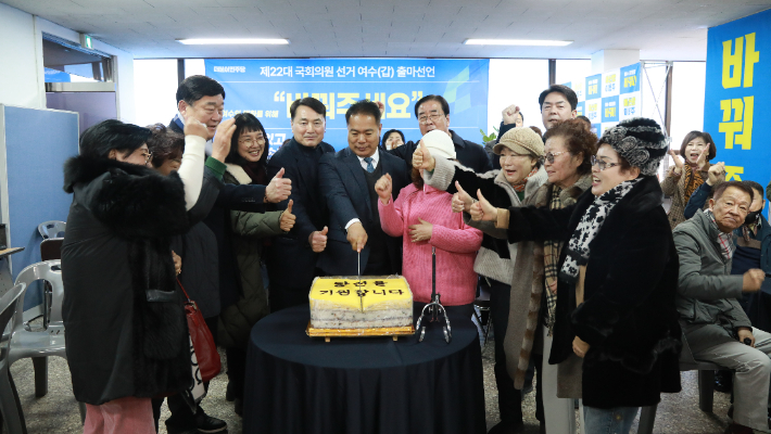 전남 여수갑 더불어민주당 이용주 예비후보가 개소식 축하 떡케익을 자르면서 지지자들과 기념촬영을 하고 있다. 이용주 제공