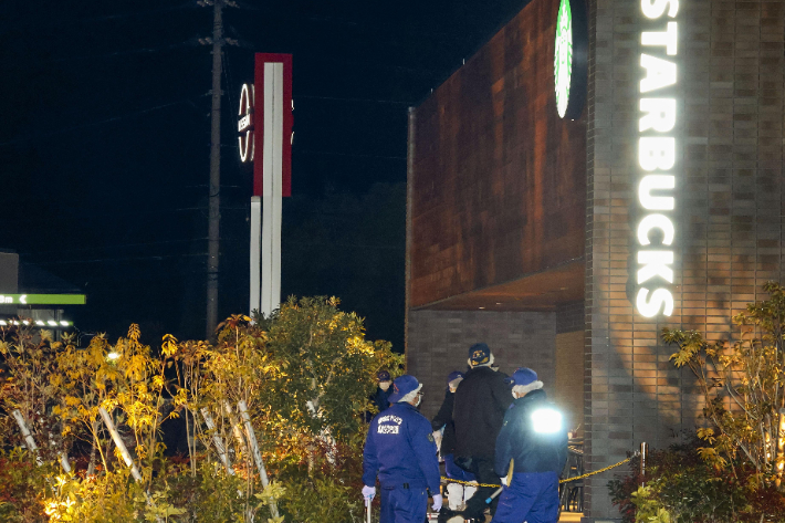 지난 14일 밤 일본 에히메현의 카페에서 발생한 총격 사건 현장에 경찰이 출동해 수사를 하는 모습. 연합뉴스