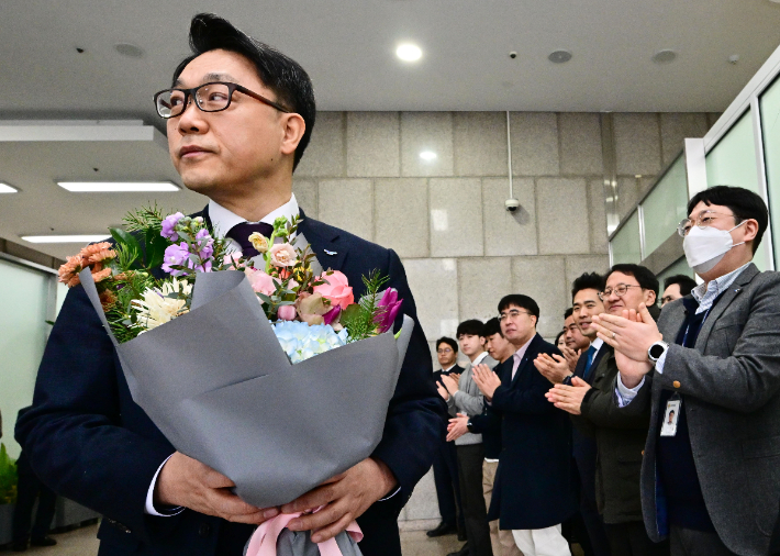 김진욱 고위공직자범죄수사처장이 19일 오전 정부과천청사 공수처에서 열린 이임식을 마친 뒤 건물을 나서며 직원들로부터 꽃다발을 받고 있다. 연합뉴스