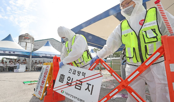 전북 임실군 임실축협에서 열린 '2023 아프리카돼지열병 가상방역훈련'에서 의심축 신고농장에 도착한 가축위생방역본부 초동방역팀이 개인별 소독 후 표지판과 접근 금지띠를 설치하고 있다. 임실군청 제공