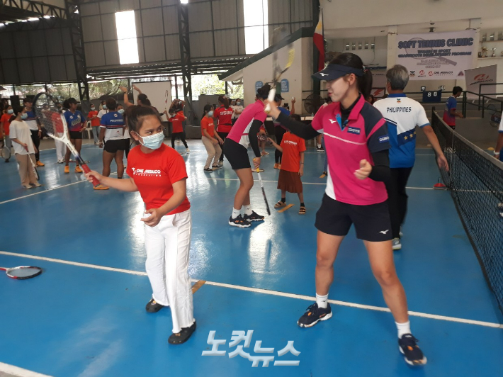 DGB대구은행 김한설(오른쪽)이 19일(한국 시각) 필리핀 마닐라 지역 유소년에게 스트로크를 지도하고 있다. 노컷뉴스