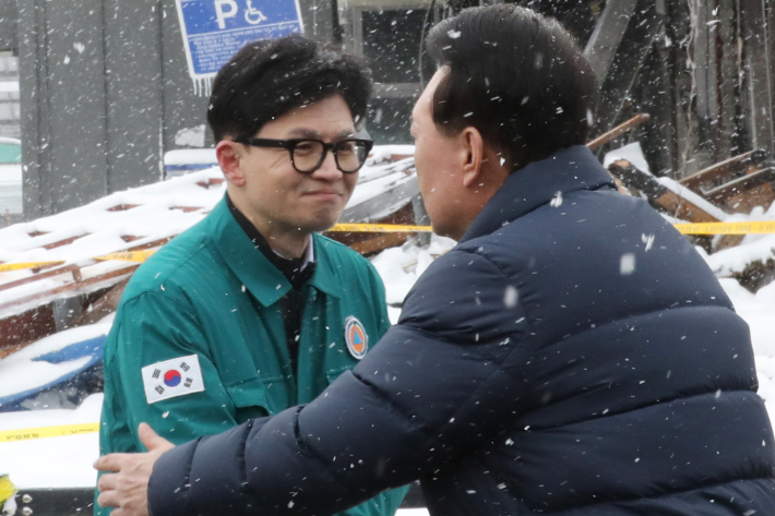 윤석열 대통령이 23일 충남 서천군 서천읍 서천특화시장 화재 현장에서 국민의힘 한동훈 비상대책위원장과 만나 인사하는 모습. 연합뉴스