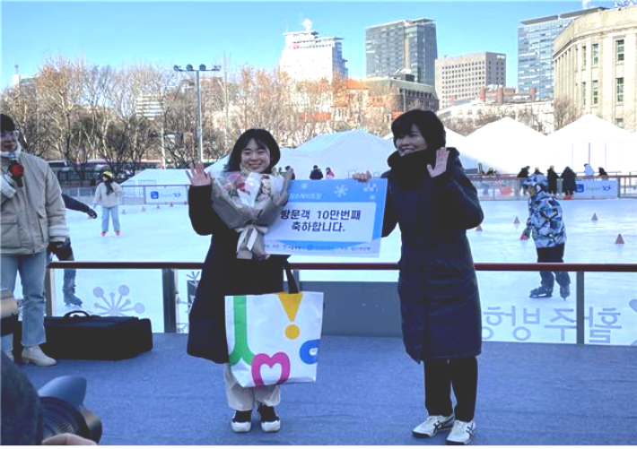 서울광장 스케이트장에 올해 10만번째 방문한 문가량(24·사진 왼쪽)씨가 기념 촬영을 하고 있다. 서울시 제공