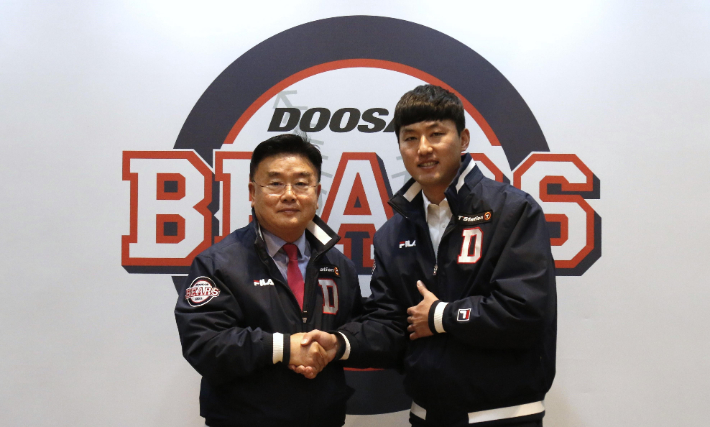 홍건희(오른쪽)가 25일 서울시 잠실구장 두산 베어스 사무실에서 FA 계약을 한 뒤 김태룡 단장과 악수하고 있다. 두산 베어스