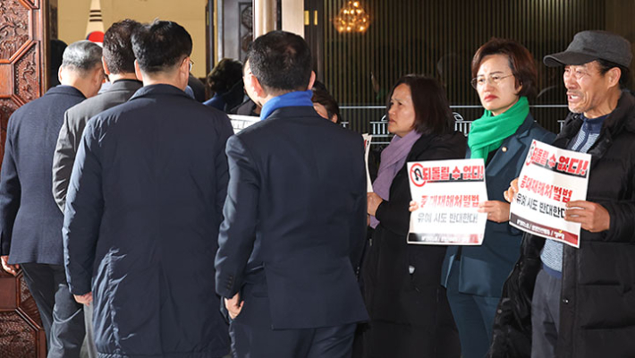  1일 국회에서 열린 더불어민주당 의원총회 앞에서 정의당과 노동계 관계자들이 회의장으로 향하는 의원들을 향해 중대재해처벌법 유예 반대 입장을 피력하고 있다. 연합뉴스