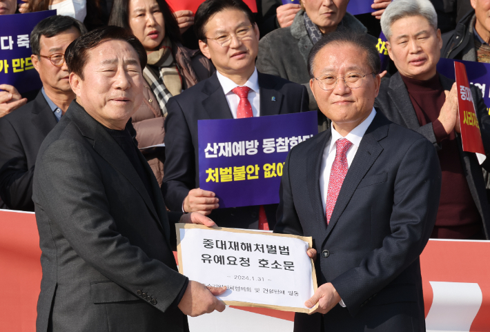 31일 국회 앞에서 열린 50인 미만 사업장 중대재해처벌법 유예 불발 규탄 대회에서 김기문 중소기업중앙회장이 국민의힘 윤재옥 원내대표에게 호소문을 전달하고 있다. 연합뉴스