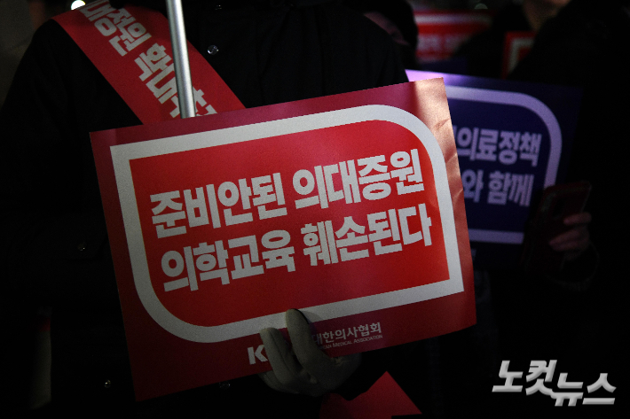 대한의사협회 산하 서울시의사회 회원들이 15일 서울 용산구 대통령실 앞에서 열린 정부의 의대 증원 방침 반대 궐기대회에서 피켓을 들고 있다. 박종민 기자