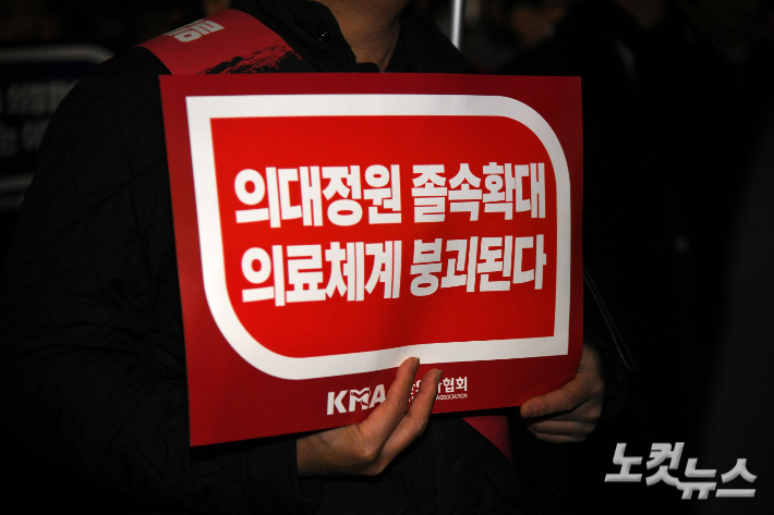 대한의사협회 산하 서울시의사회 회원들이 15일 서울 용산구 대통령실 앞에서 열린 정부의 의대 증원 방침 반대 궐기대회에서 피켓을 들고 있다. 박종민 기자