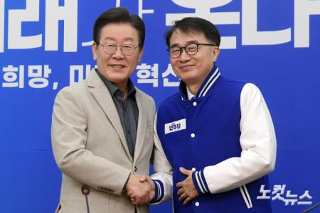 당 점퍼 전달하고 악수하는 이재명-김준환