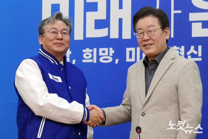 당 점퍼 전달하고 악수하는 이재명-손명수