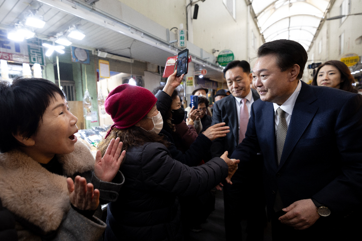윤석열 대통령이 22일 경남 창원시 마산합포구 마산어시장을 찾아 시민들과 인사하고 있다. 연합뉴스 