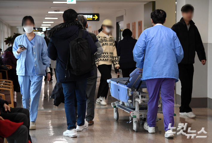 전공의들이 의대 증원에 반대하며 파업에 돌입한 지 이틀째인 21일 오전 서울 시내 한 대학병원에서 의료진이 이동하고 있다. 황진환 기자