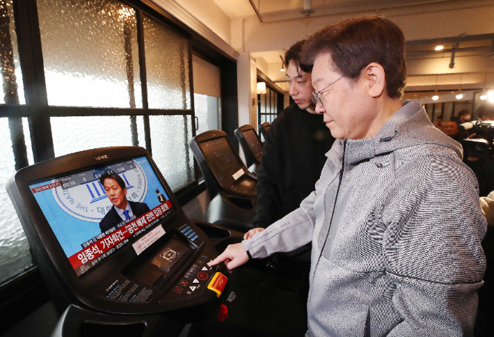 이재명 더불어민주당 대표가 28일 오전 서울 서대문구 매직짐 휘트니스에서 러닝머신을 이용하는 중, 화면에 임종석 전 대통령비서실장의 공천 관련 기자회견 모습이 보이고 있다. 국회사진취재단