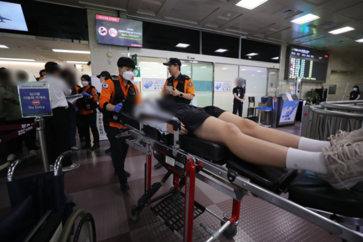 지난해 5월 26일 제주를 출발해 대구로 향하던 아시아나 항공기에서 비행 중 문이 열리는 사고가 발생했다. 당시 비행기에 탑승했던 초·중학생 제주도선수단 가운데 대구공항 도착 후 고통을 호소하는 선수들을 119구조대가 들것을 이용해 구급차로 옮기고 있는 모습. 연합뉴스