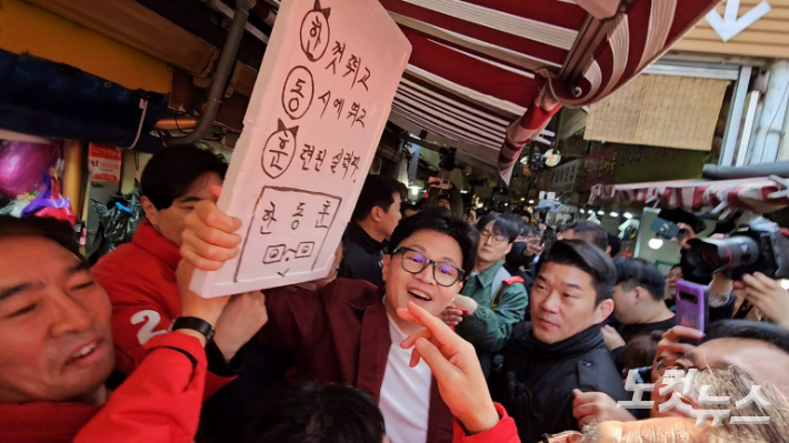 14일 오전 부산 북구 구포시장 찾은 한동훈 국민의힘 비상대책위원장이 한 상인이 만든 응원 피켓을 받아들고 흔들어 보이고 있다. 김혜민 기자