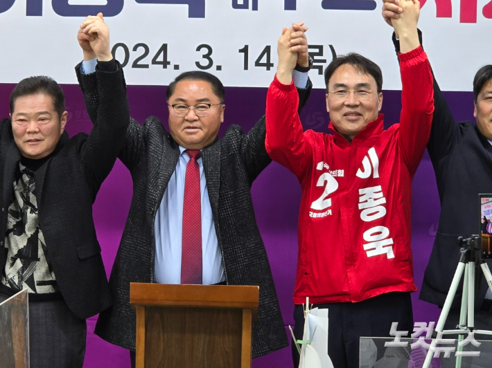 박춘덕 전 경남도의원(사진 왼쪽에서 두번째)와 이종욱 후보가 손을 잡고 있다. 이상현 기자